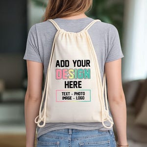 May include: A cream-colored drawstring backpack with the text "ADD YOUR DESIGN HERE" in black, pink, yellow, and teal. The text "TEXT - PHOTO - IMAGE - LOGO" is below in a pink and teal outlined box. The backpack is worn over the shoulders.