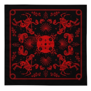 May include: A black bandana with a red repeating pattern of skeletons riding horses, scorpions, and stars. The bandana has a red rope border.