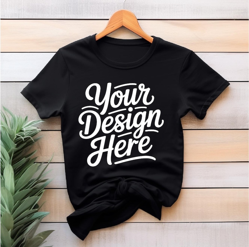 K&ouml;nnte beinhalten: Ein schwarzes T-Shirt mit dem Text "Your Design Here" in wei&szlig; auf der Vorderseite.