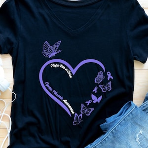 May include: Black t-shirt with a purple heart design featuring butterflies and the text "Hope for a Cure, Ovarian Cancer Awareness".