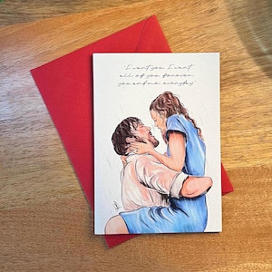 Op de afbeelding: Een rechthoekige wenskaart met een rode envelop met een handgetekende illustratie van twee mensen die elkaar in de regen omhelzen. De tekst luidt: I want you. I want all of you, forever, you and me, everyday. Eén persoon draagt een blauwe jurk.