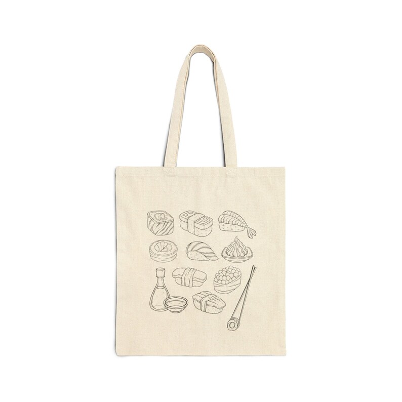 A cream canvas tote bag with a black line art sushi graphic is displayed flat against a white background.