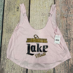 May include: Pink sleeveless tank top with a brown and gold graphic of a can with the text "Lake Mode".