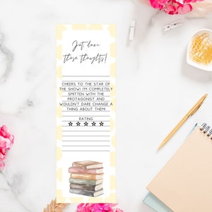 Op de afbeelding: Een gele bladwijzer met een stapel boeken en de tekst "Jot down those thoughts!"  "Cheers to the star of the show! I'm completely smitten with the protagonist and wouldn't dare change a thing about them!"  "Rating" en vijf sterren.