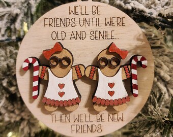 May include: A wooden Christmas ornament with two gingerbread people holding hands. The ornament reads "We'll be friends until we're old and senile... Then we'll be new friends."