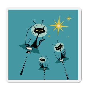 May include: Three black cats in spaceships flying through a blue sky with yellow stars. The cats are looking out of the windows of their spaceships.