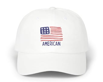 May include: White baseball cap featuring a hand-drawn American flag design. The flag has red and white stripes with blue stars and the word "AMERICAN" in blue below the flag. The cap is a classic, casual style.