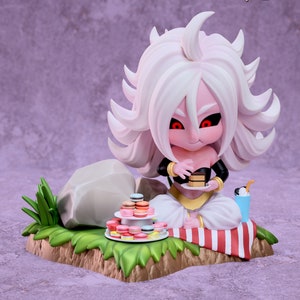 May include: A pink and white anime character with long white hair sits on a red and white striped blanket. The character is holding a piece of cake and there are macarons on a plate in front of them. The character is from the Dragon Ball Super anime series.
