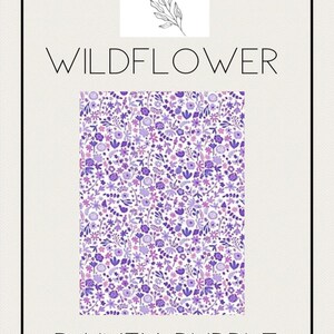 May include: A rectangular design featuring a floral pattern in shades of purple and white, with the words "WILDFLOWER" and "DAINTY PURPLE" in a minimalist font. The design is framed by a black border, with the text "joy by j&j" at the top.