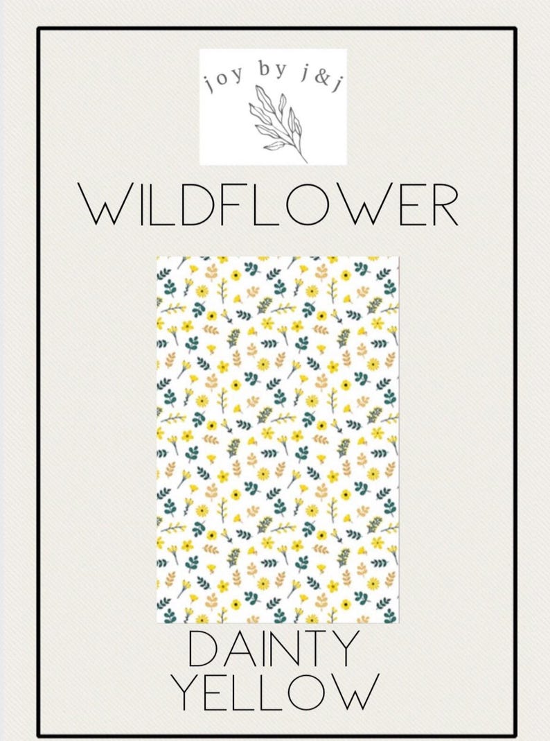 May include: A rectangular pattern with a white background, featuring a repeating design of yellow flowers, green leaves, and brown sprigs. The words "WILDFLOWER" and "DAINTY YELLOW" are displayed in large, elegant fonts. The logo "joy by j&j" is at the top.