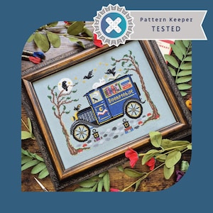May include: A framed cross-stitch embroidery featuring a blue vintage truck labeled Bookmobile, surrounded by trees, black birds, a white cat, and a moon. The design includes lanterns and stars on a light blue fabric background, with a Pattern Keeper Tested badge.
