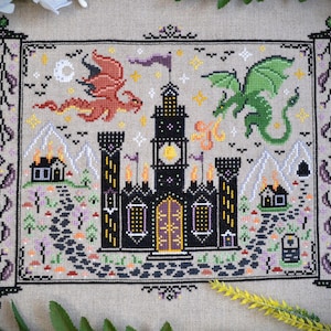 Castles & Dragons cross stitch pattern finish. Features flying fire dragon and a large castle on a scroll.