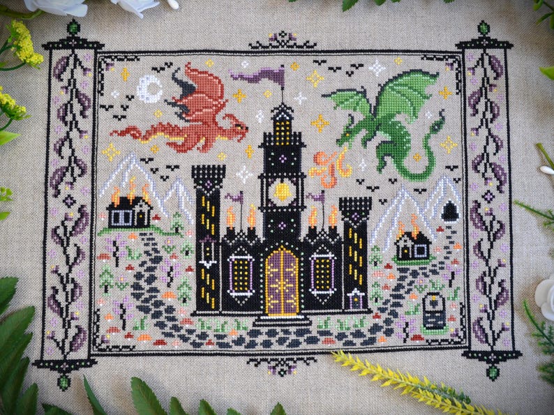 Castles & Dragons cross stitch pattern finish. Features flying fire dragon and a large castle on a scroll.