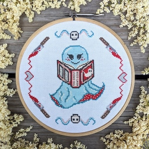May include: A blue ghost reading a book titled "The Ghost Next Door" with a red and white cover. The ghost is holding the book with its hands and has a happy expression on its face. The background is a white canvas with red and white accents.