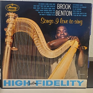 May include: A vintage vinyl record album cover featuring a black and white photo of a man playing a harp. The album is titled "Songs I Love to Sing" by Brook Benton. The album cover is a blue and white color scheme with the text "High Fidelity" in blue letters.