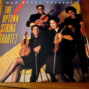 May include: The Uptown String Quartet album cover featuring four musicians playing violins. The album is presented by Max Roach.
