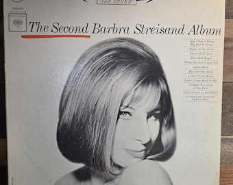 May include: A vintage vinyl record cover for The Second Barbra Streisand Album. The white cover features a black and white portrait of Barbra Streisand, the Columbia logo, Stereo 360 Sound text, and a tracklist on the right side of the sleeve.