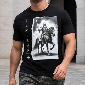 Puede incluir: Una camiseta negra de manga corta con un estampado gráfico de un caballero con armadura montando un caballo y sosteniendo una espada. El texto "TEMPLAR KNIGHT" y un símbolo de cruz están impresos verticalmente en blanco a la izquierda.