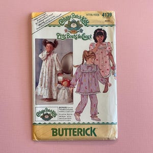 May include: A vintage Butterick sewing pattern for Cabbage Patch Kids outfits. The pattern features illustrations of children in pyjamas and nightgowns. The pattern number is 4139, sized for children ages 4-5-6. Includes iron-on transfers.