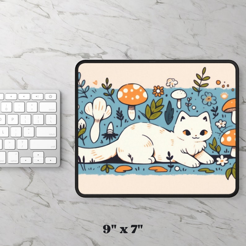 May include: A rectangular mousepad with a whimsical illustration of a white cat lounging amidst cartoon mushrooms, flowers, and foliage. The mousepad measures 9 inches by 7 inches. The design features a light blue background with a cream-colored border.