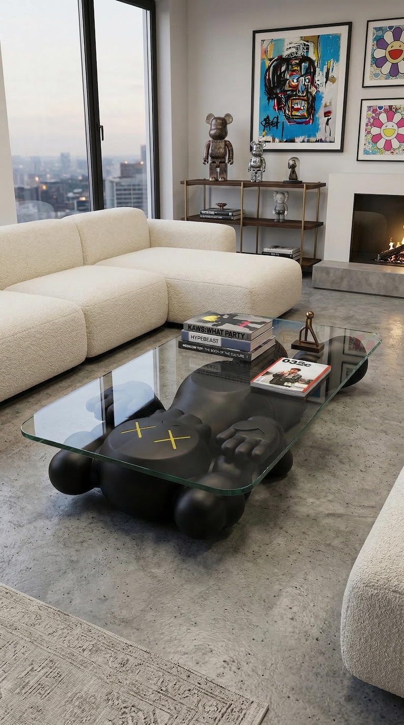 Pode incluir: Uma sala de estar moderna com uma mesa de centro preta com design KAWS com tampo de vidro. A mesa tem um design de figura &uacute;nico com olhos amarelos em forma de cruz. Livros e itens decorativos s&atilde;o colocados na mesa. Um sof&aacute; branco e obras de arte est&atilde;o ao fundo.