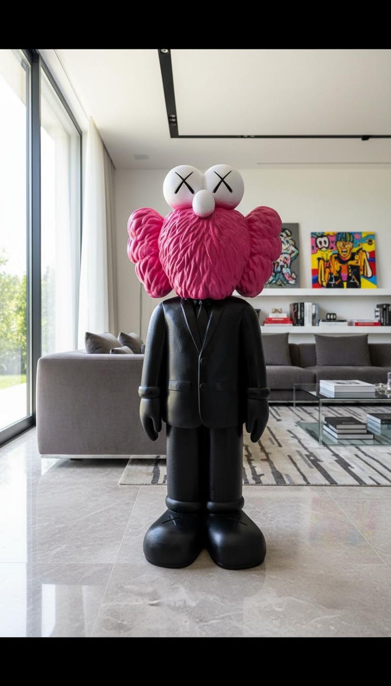 May include: A large black sculpture of a cartoon figure wearing a suit, with a pink head and ears, and white eyes with black X's. The figure is standing in a modern living room with large windows and artwork.