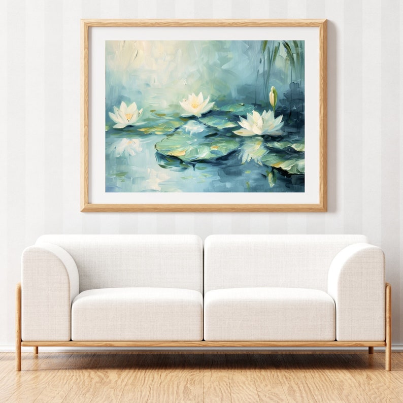 May include: A painting of white water lilies on a blue pond with green lily pads. The painting is framed in a light wood frame.