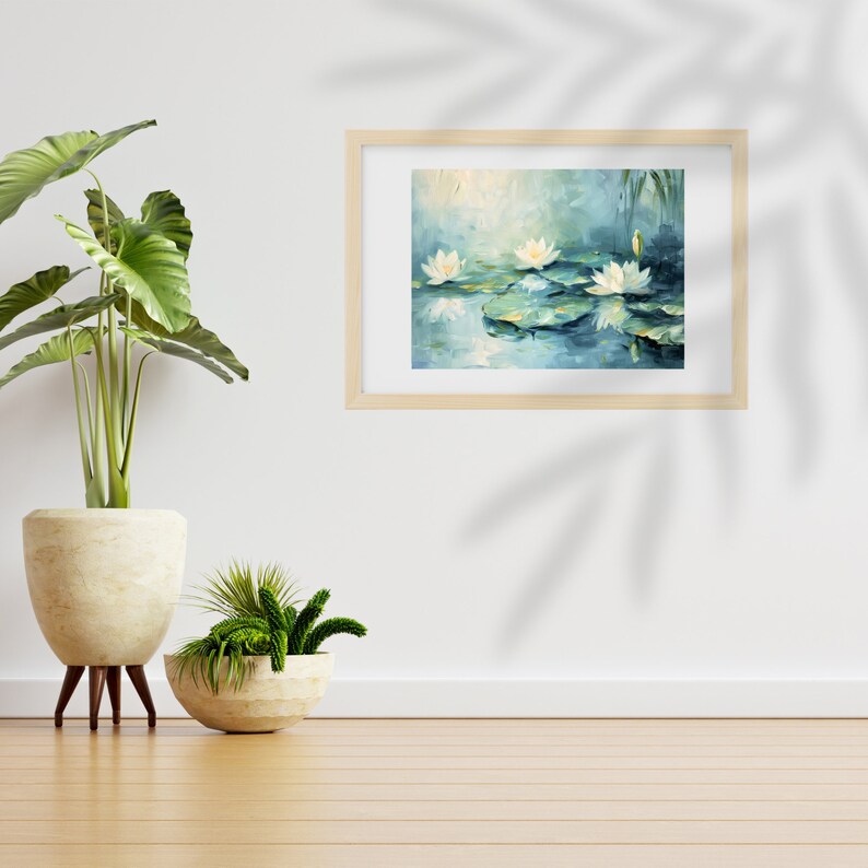 May include: A framed painting of white water lilies on a blue pond with green lily pads. The painting is in a light wood frame and is hanging on a white wall.