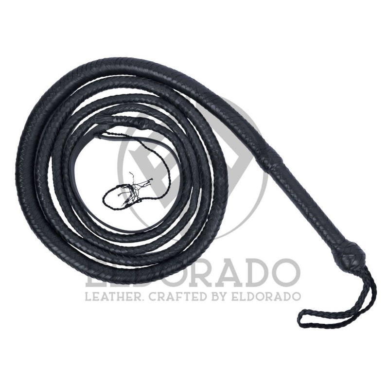 K&ouml;nnte beinhalten: Eine schwarze Lederpeitsche, aufgerollt und vor wei&szlig;em Hintergrund. Die Peitsche ist geflochten und hat einen Griff mit geknotetem Ende und einer Schlaufe. Der Text "ELDORADO LEATHER. CRAFTED BY ELDORADO" ist sichtbar.