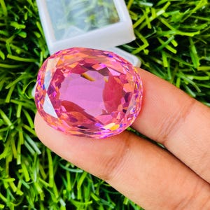Peut inclure: Une grande pierre pr&eacute;cieuse rose de forme ovale, facet&eacute;e, avec un haut poli. La pierre pr&eacute;cieuse a une l&eacute;g&egrave;re qualit&eacute; iridescente.