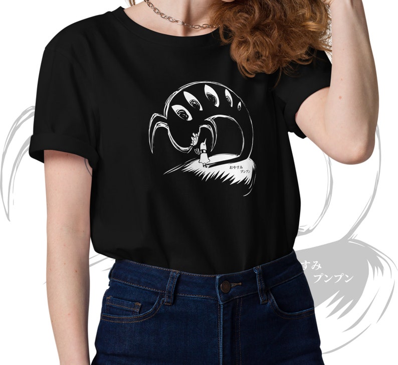 May include: Black t-shirt featuring a white graphic of a creature with multiple eyes and a figure. The design includes Japanese text. The shirt is a short-sleeved crew neck.