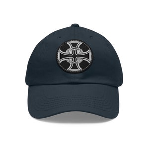 May include: A navy blue baseball cap with a black and silver iron cross patch on the front.