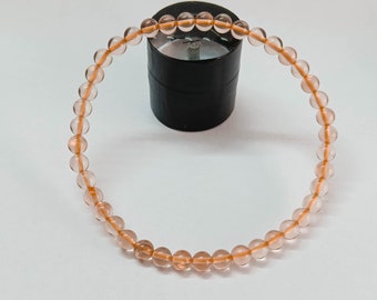 May include: A bracelet made of light pink and orange gemstone beads.