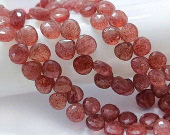 May include: A strand of faceted, reddish-brown gemstone beads. The beads are round and have a slightly irregular shape.