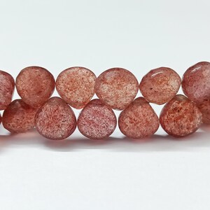 May include: A strand of translucent red gemstone beads with a faceted, teardrop shape.