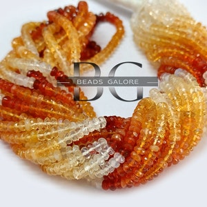 May include: A strand of orange, yellow, and white gemstone beads. The beads are faceted and have a smooth, polished finish. The strand is approximately 16 inches long and is perfect for making jewelry.