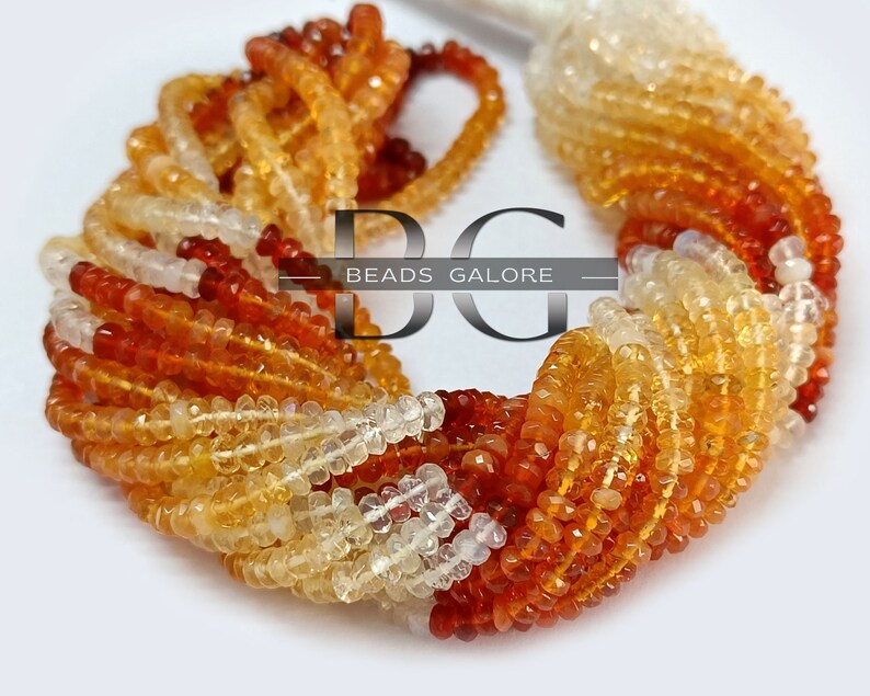 May include: A strand of orange, yellow, and white gemstone beads. The beads are faceted and have a smooth, polished finish. The strand is approximately 16 inches long and is perfect for making jewelry.