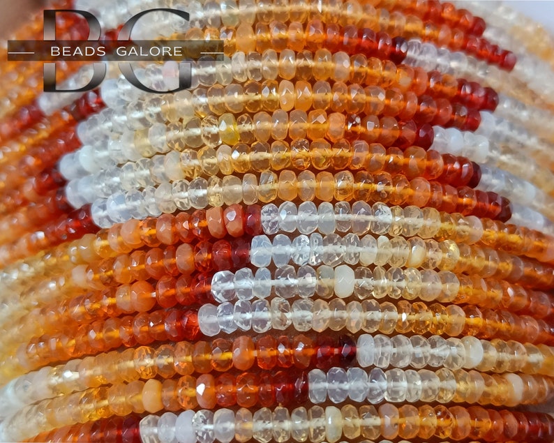 May include: A strand of multi-colored gemstone beads. The beads are small and round, and they are arranged in a repeating pattern of white, orange, and red. The beads are strung on a clear thread.