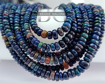 May include: A strand of dark blue opal beads, with iridescent flashes of color. The beads are round and have a slightly irregular shape. The strand is approximately 18 inches long.