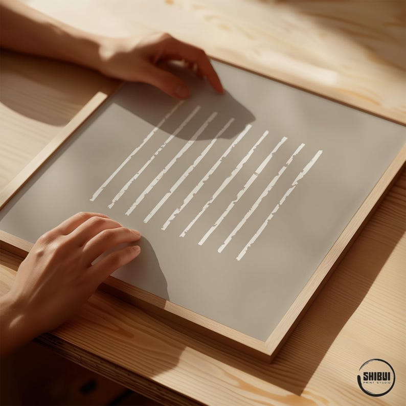 May include: A square framed print featuring a solid taupe background with ten vertical white lines of varying lengths. The frame is made of light-colored wood. The text SHIBUI PRINT STUDIO is visible in the bottom right corner of the image.