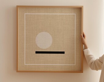 May include: A square wall art piece featuring a textured beige linen background enclosed in a light wood frame. The design includes a thin white square border, a solid white circle positioned in the upper left quadrant, and a thick black horizontal line.