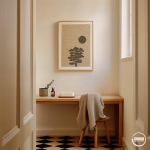 K&ouml;nnte beinhalten: Ein gerahmter, rechteckiger Wandkunstdruck mit der Silhouette eines dunkelgrauen Baumes und einem einfarbigen dunkelgrauen Kreis auf strukturiertem beigem Hintergrund. Der Druck h&auml;ngt an einer hellen Wand &uuml;ber einem Schreibtisch aus Holz.