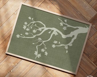 May include: A framed art print with a white floral branch design on a muted green backdrop. The artwork is set within a light wood frame, creating a natural aesthetic. The print is ideal for adding a touch of nature-inspired decor to a room.