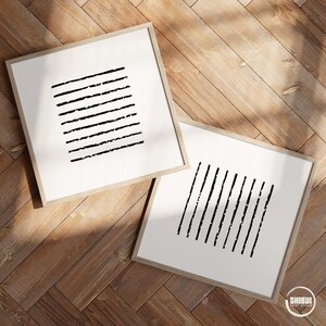 May include: Two square framed wall art pieces featuring black ink-style lines on a white background. One frame displays horizontal lines, while the other shows vertical lines. Both frames are light wood. The text SHIBUI PAINT STUDIO is visible.