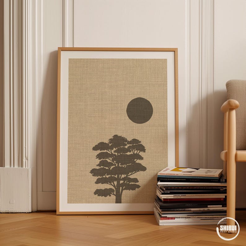 K&ouml;nnte beinhalten: Ein gerahmter rechteckiger Wandkunstdruck mit einem strukturierten beigen Hintergrund, einer dunkelgrauen Silhouette eines Baumes und einem massiven dunkelgrauen Kreis, der die Sonne oder den Mond &uuml;ber der Baumkrone im oberen rechten Quadranten darstellt.