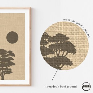 K&ouml;nnte beinhalten: Ein gerahmter Kunstdruck mit der dunkelbraunen Silhouette eines Baumes und einer kreisf&ouml;rmigen Sonne auf beigem Hintergrund in Leinenoptik. Das Bild enth&auml;lt eine kreisf&ouml;rmige Detailansicht mit dem Text museum quality posters und linen-look background.