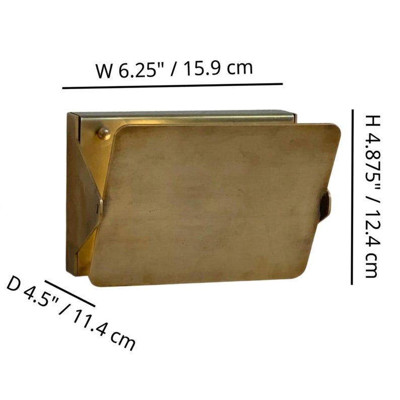 May include: A brass-colored, rectangular wall-mounted mailbox with a hinged door. The mailbox is 6.25 inches wide, 4.875 inches high, and 4.5 inches deep. The door is open, revealing the interior.