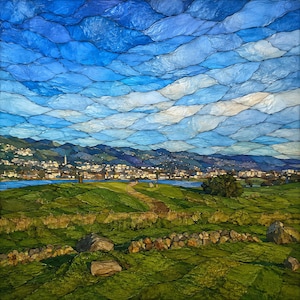 May include: A square landscape artwork featuring a vibrant blue sky with layered, cloud-like textures above a green rolling meadow. A stone wall crosses the foreground, leading toward a distant town nestled along a body of water and dark mountains.