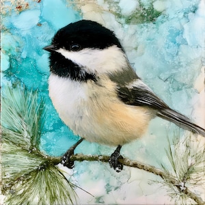 May include: A square art piece featuring a black-capped chickadee perched on a pine branch. The bird has a black head, white cheeks, and a tan-colored chest. The background is an abstract wash of light blue, white, and green ink tones.
