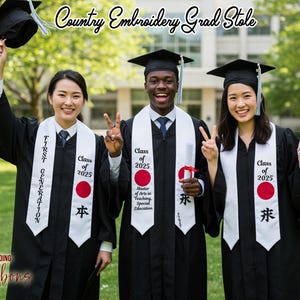 May include: Three graduates in black gowns and mortarboards, each with a white sash featuring text and a red circle. The sashes read "Class of 2025" and include Japanese characters. The image also displays the text "Country Embroidery Grad Stole".